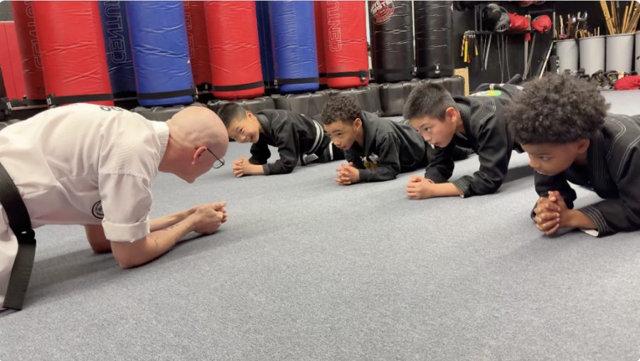 Kids Karate instructor doing a plank drill alongside young students at Baltimore Martial Arts Academy